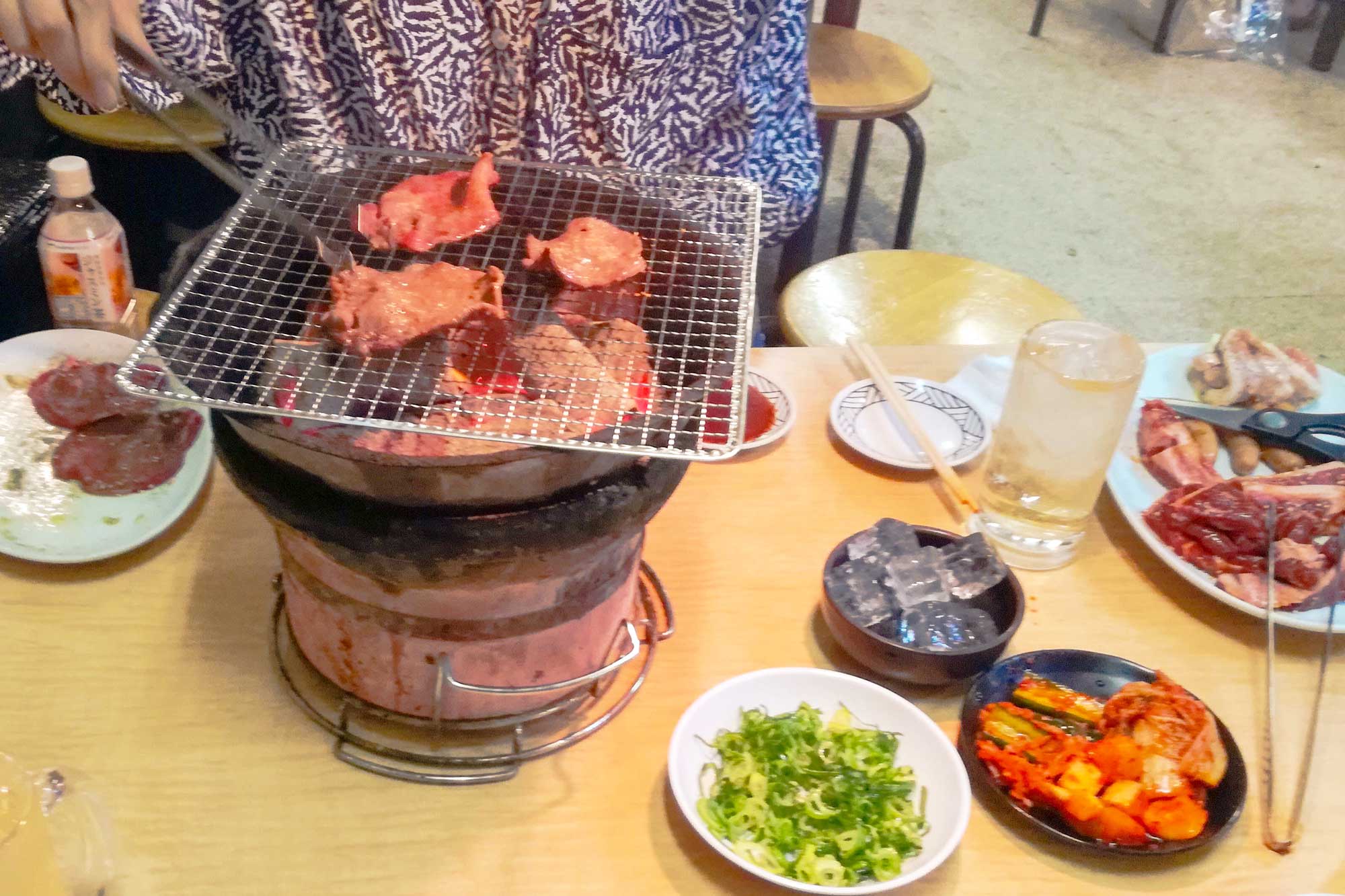 A table with Yakiniku and a grill on top of the table